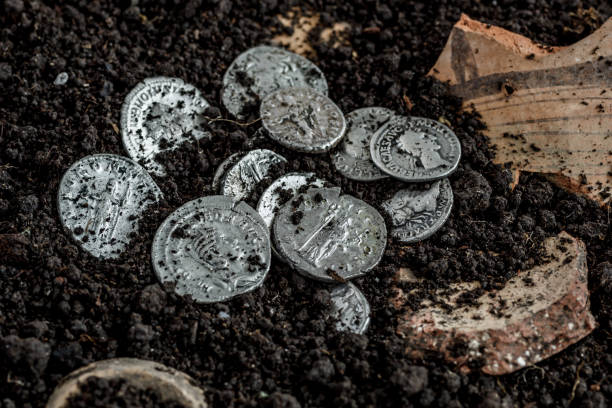 Ancient coin of the Roman Empire.Authentic silver denarius, antoninianus of ancient Rome.Roman silver coins covered in dirt.Antikvariat. stock photo