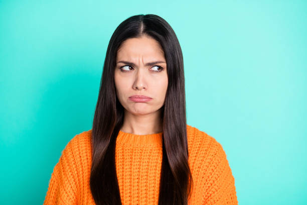 istock Photo of grumpy young woman look side empty space wear orange pullover isolated teal color background 1340218696