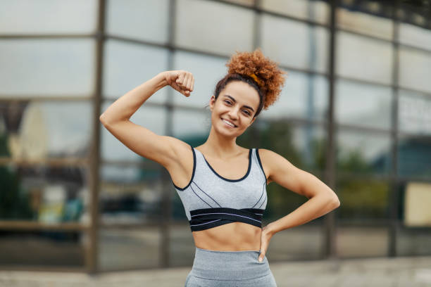istock A young, strong, and happy sportswoman is showing her biceps while standing outdoors. Strength comes with effort and persistence, and the benefits are a happier and healthier life. 1340218808