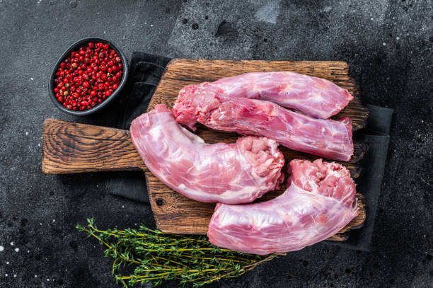 istock Raw Turkey neck meat on a butcher wooden board. Black background. Top View 1340220138