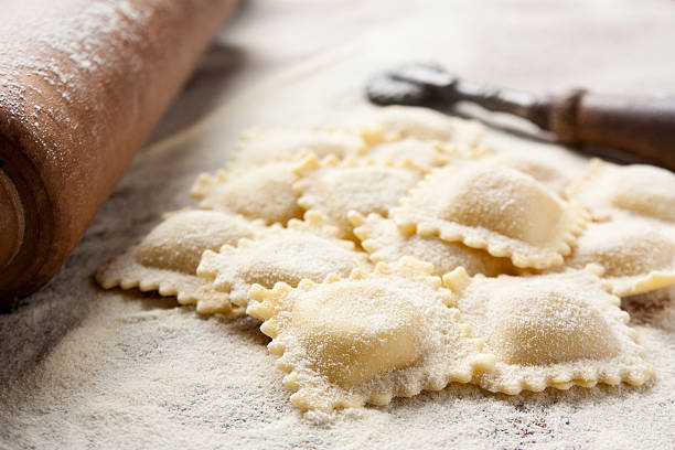 Close up of homemade ravioli and tools Making homemade ravioli with a wooden roller homemade stock pictures, royalty-free photos & images