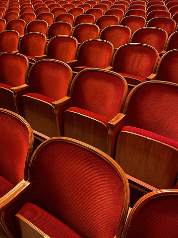 Row of old wooden red chairs in theater.