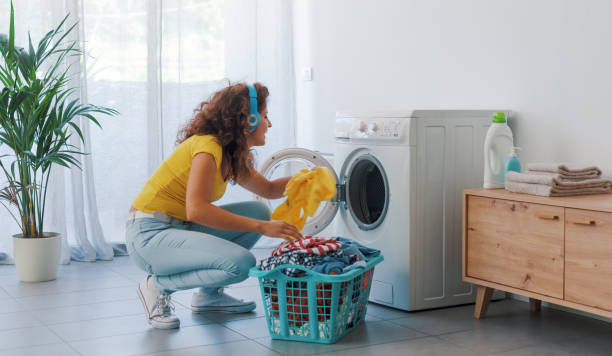 joven feliz lavando la ropa - all laundry detergent audio fotografías e imágenes de stock
