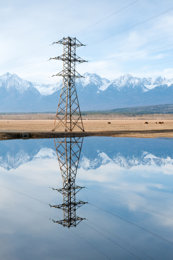 Power line above water. Mountains background