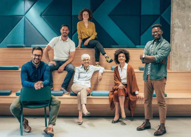 Successful team Group of multi ethnic creative people in smart casual wear looking at camera and smiling in creative office workplace. Coworker teamwork concept. organized group photos stock pictures, royalty-free photos & images