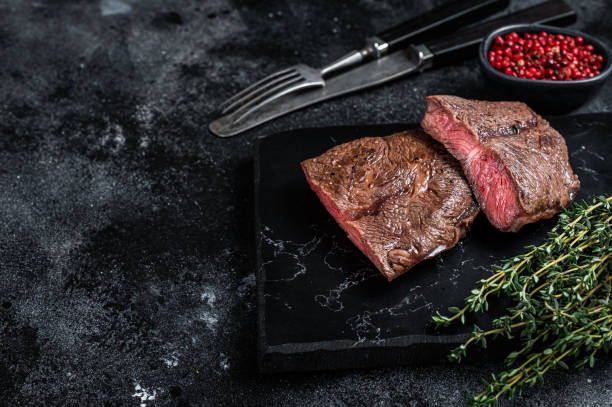 istock Grilled Top Blade or flat iron roast beef meat steaks on marble board. Black background. Top View. Copy space 1340227543