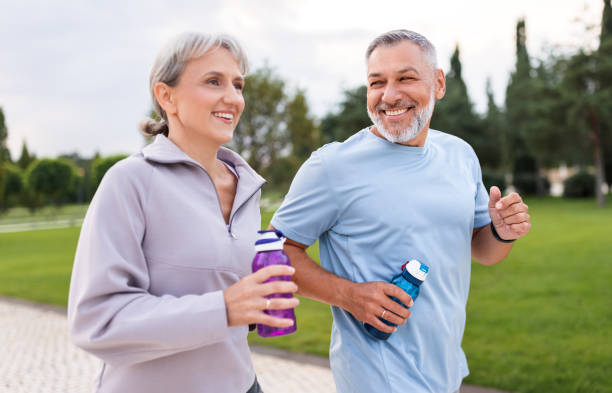 istock Lovely joyful retirees couple jogging outside in city park 1340228708