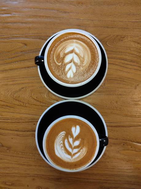 istock Two cups of cappuccino on a wooden table 1340228960