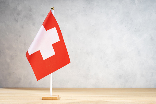 Switzerland table flag on white textured wall. Copy space for text, designs or drawings