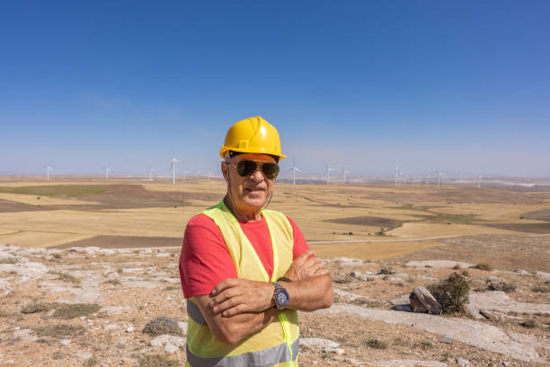 Worker wearing safety gear talking to the mobile phone in a wind energy park
