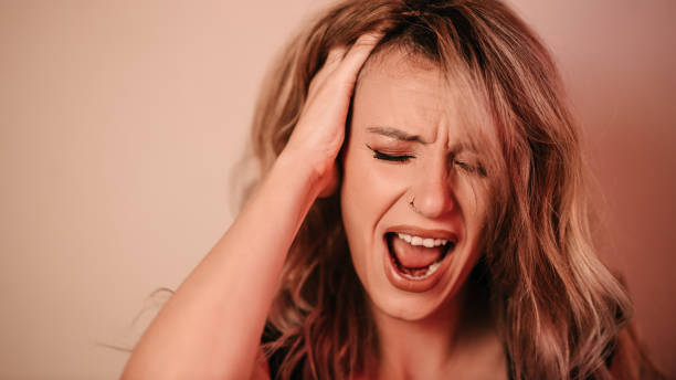 istock Woman holding her head and screaming 1340231793