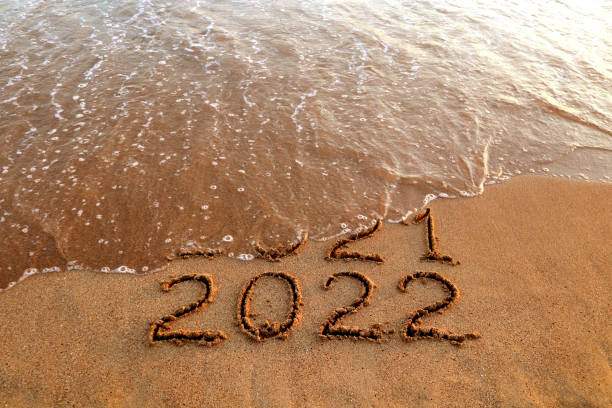 New year 2022 and 2021 on sandy beach with waves New year 2022 and old year 2021 on sandy beach with waves 2022 stock pictures, royalty-free photos & images