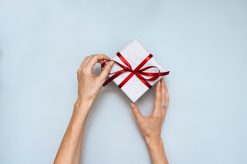 Directly above photo of unrecognizable woman hands preparing gift for xmas eve