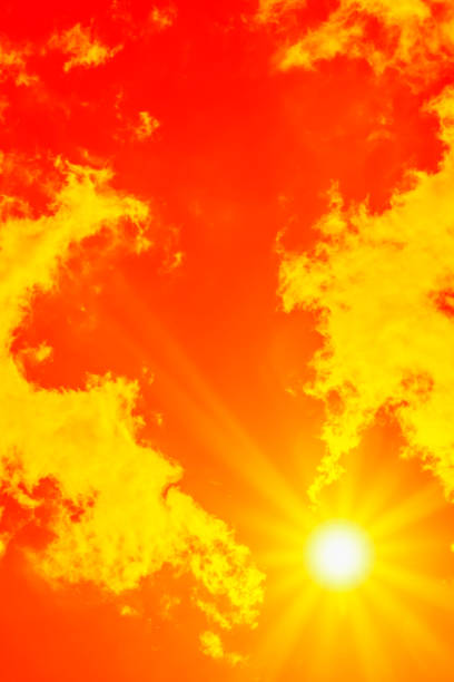 istock Bright sun with beautiful beams in the sky with clouds (toned in red) 1340233301