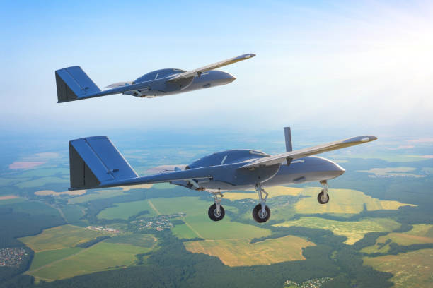 Pair of unmanned military drones with extended landing gear fly by patrol air territory at low altitude. Pair of unmanned military drones with extended landing gear fly by patrol air territory at low altitude legal defense photos stock pictures, royalty-free photos & images