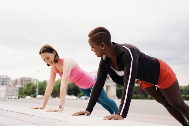 istock Two beautiful women making plank in city square during sport activity 1340237215