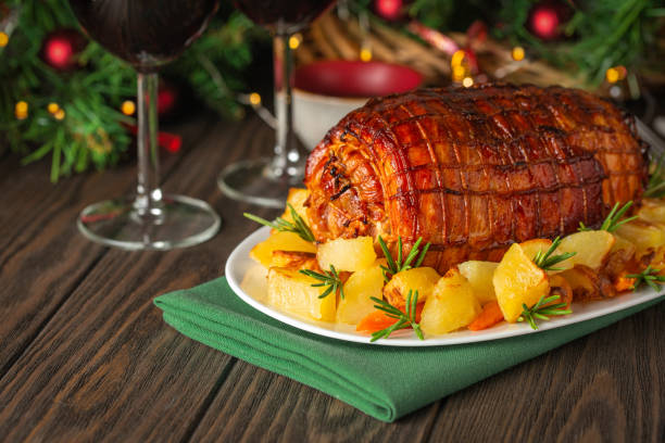 Baked veal roulade with potato Baked veal roulade with potato and rosemary. Red wine glasses. Christmas holiday dinner on a dark wooden table with a Christmas tree and New Year's toys. Copy space. roast dinner stock pictures, royalty-free photos & images