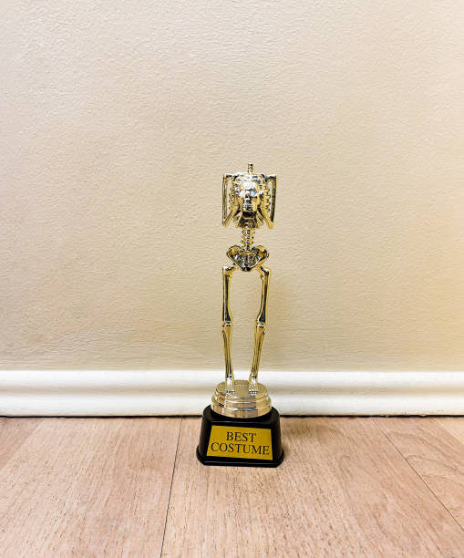 golden award halloween trophy skeleton bones with scull in hands, best costume headline on a floor - oscar statuette imagens e fotografias de stock