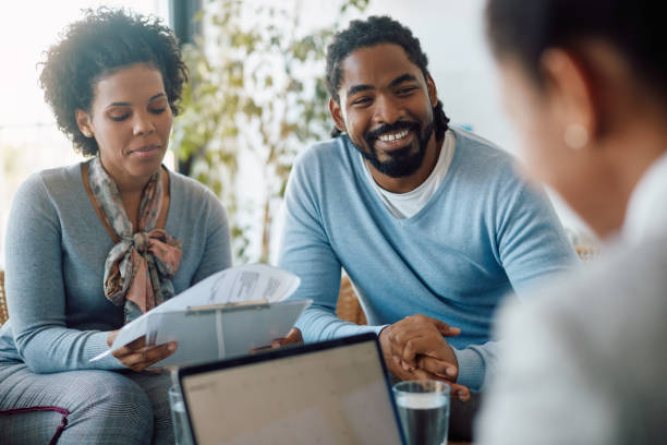 istock Happy black couple going through paperwork while being on a meeting with financial advisor. 1340241742