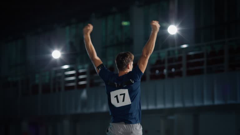 Pole Vault Jump Championship: Professional Male Athlete Running with Pole Successfully Jumping over Bar, Raising Arms, Celebrating. Determination, Motivation of Champion in Training. Slow Motion Shot