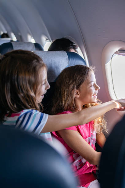 istock Girls looking through window while traveling whit airplane 1340243691