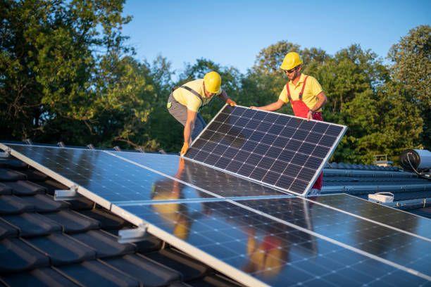 Construction Workers Installing Solar Panels On A Rooftop stock photo