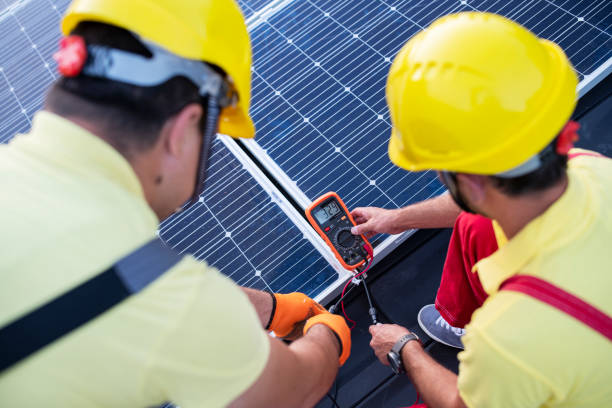 Power Engineers Using Multimeter On Solar Panels Power Engineers Mesuring Solar Energy On Panels On A Roof Of A House electrician multimeter stock pictures, royalty-free photos & images
