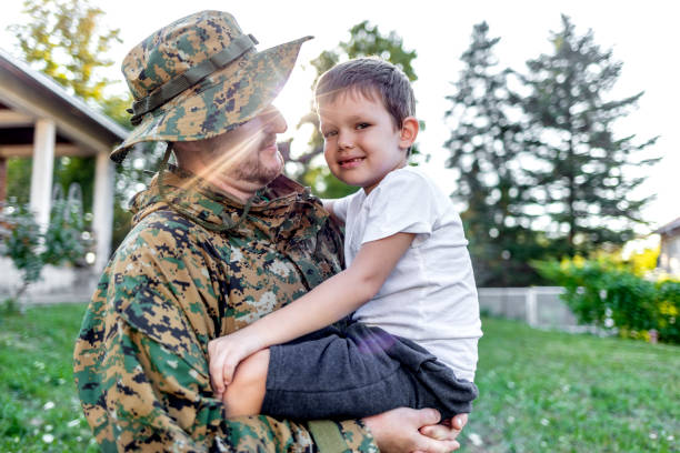 istock Cheerful brown haired son smiling while looking at daddy after military service. 1340246458