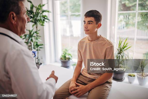 Oberarzt Spricht Mit Jugendlichem Patienten Im Medizinischen Untersuchungsraum Stockfoto und mehr Bilder von Teenager-Alter