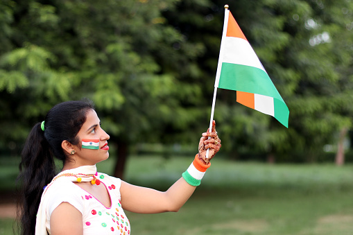 Young woman with holding tricolor Indian flag in hand on Independence day, 15, August, India.
