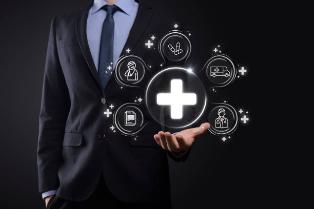 istock Businessman hold virtual plus medical network connection icons. Covid-19 pandemic develop people awareness and spread attention on their healthcare.Doctor,document,medicine,ambulance,patient icon. 1340252300