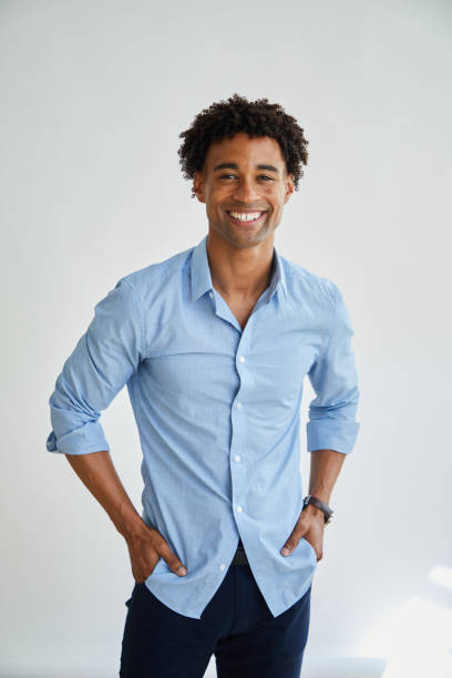 Casual young businessman smiling against a white background