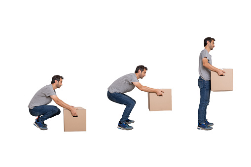 Un hombre se puso en movimiento levantando una caja aislada sobre fondo blanco. photo