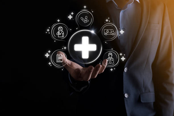 istock Businessman hold virtual plus medical network connection icons. Covid-19 pandemic develop people awareness and spread attention on their healthcare.Doctor,document,medicine,ambulance,patient icon. 1340253526
