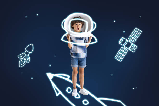 istock Creative artwork of little boy standig on drawn rocket isolated over dark blue background with drawn spaceships 1340255363