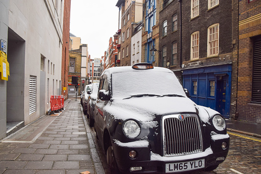 London, United Kingdom - February 8 2021: Snow on a London taxi in Covent Garden.