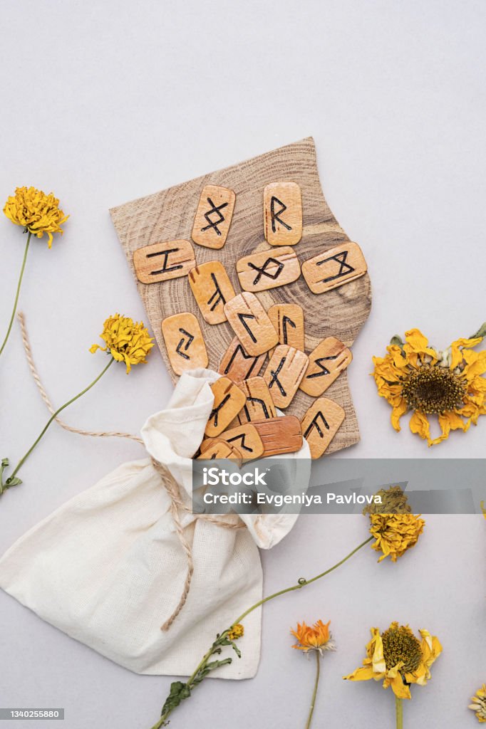 Scandinavian wooden runes and dried flower. Handmade dies in linen bag, flat lay with copy space. Runes Stock Photo