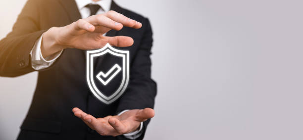istock Male hand holding protect shield with a check mark icon on blue background. Protection network security computer and safe your data concept . 1340257501