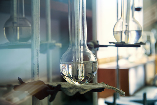 Vintage equipment of chemical laboratory. Antique lab glass flasks. Chemical cabinet.