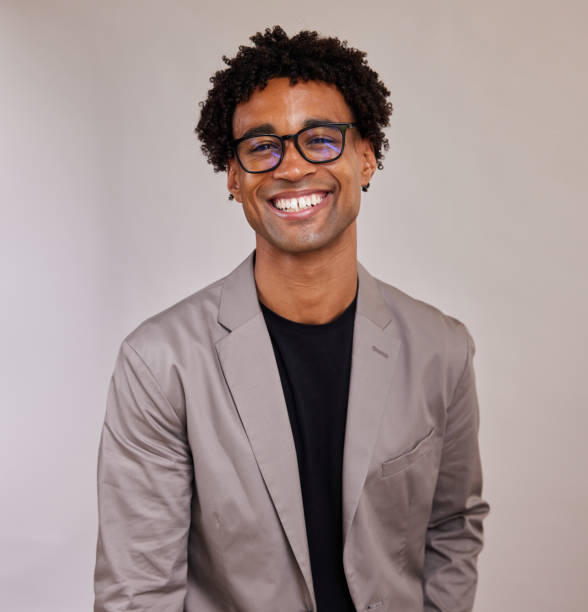 istock Young businessman laughing while standing against a gray background 1340258417