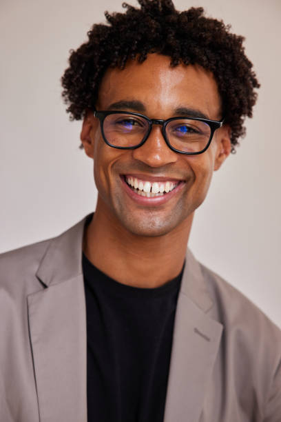 istock Young businessman smiling while standing against a gray background 1340258476