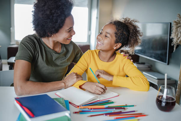 istock Caring mother assists her daughter in writing homework 1340262638