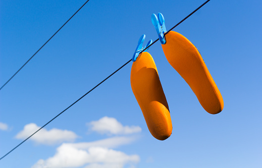 Orange footwear insoles drying on clothes or laundry line