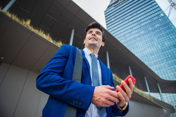 istock Handsome executive looking away while standing at the street 1340262787