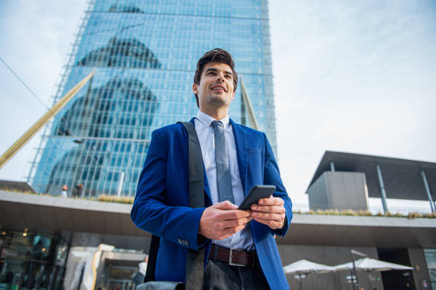 istock Handsome executive looking away while standing at the street 1340262835