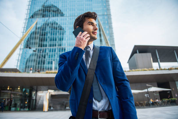 istock Handsome executive looking away while standing at the street 1340263387