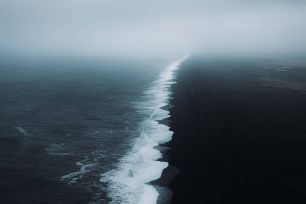 Dramatic view of the black sand beach with ocean during storm and wind in South Iceland