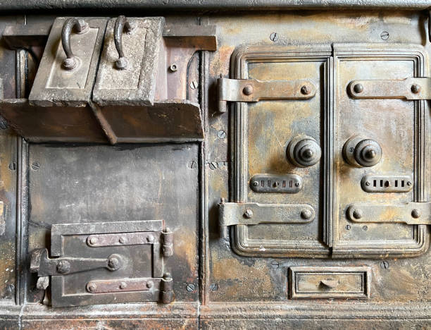 Old heavy cast iron cooking range with doors and loading chute are historic reminders of the traditional English country kitchen, England, UK