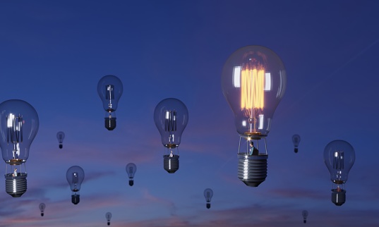Flying lightbulb balloons and the glowing one on the top, symbolizing big ideas, innovation, leadership concepts. (3d render)