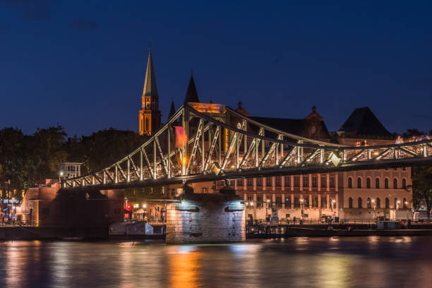 The illuminated footbridge called Eiserner Steg which crosses the river Main in Frankfurt, Germany, at night